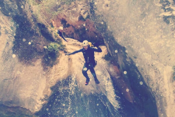 persona haciendo barranquismo y tirandose en una zona brava